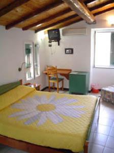 Un dormitorio con una cama amarilla con una flor. en Locanda Ca Dei Duxi, en Riomaggiore