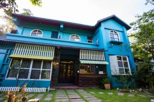 una casa azul con la puerta principal abierta en Xiangyang Tianyuan, en Sanyi