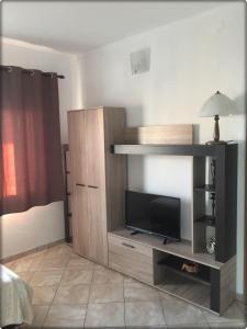 a large wooden entertainment center with a flat screen tv at Apartmani Labovic in Budva