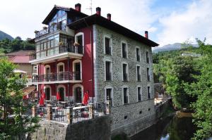un gran edificio a orillas de un río en Akla La Casa Del Puente, en Regules
