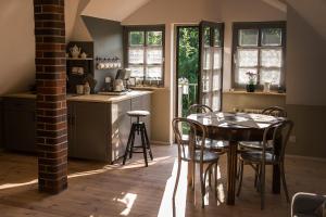 a kitchen with a table and chairs in a room at Jadą Goście in Piasek