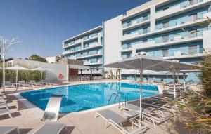 a swimming pool with chairs and an umbrella and a building at Blue Lagoon City Hotel in Kos Town