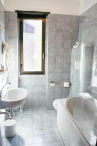 a white bathroom with a tub and a sink at Villa San Carlo in Cortemilia