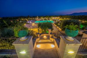 a view of a resort with a pool at night at Casal Sikelio in Cassibile