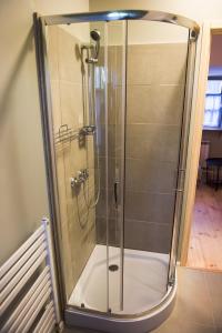 a shower with a glass door in a bathroom at Jadą Goście in Piasek