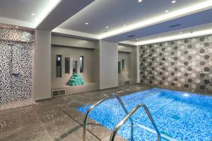 a large pool in a room with a tile wall at Blue Lagoon City Hotel in Kos