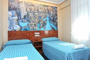 a hotel room with two beds and a painting on the wall at Hostal Venecia in Azagra