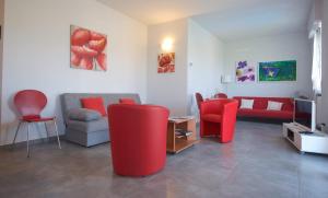 a living room with red chairs and a couch at Casa Lorenzo in Bardolino