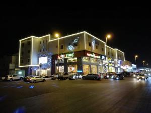 un edificio con coches estacionados en un estacionamiento por la noche en Farha International Residential Units, en Yeda