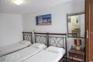 two twin beds in a room with a mirror at Studio Eleni in Mikonos