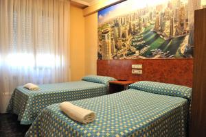 a hotel room with two beds and a television at Hostal Venecia in Azagra