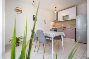 a kitchen with a table and chairs and a refrigerator at Apartman Šesna in Bol