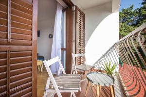 a balcony with chairs and a table on a balcony at Apartman Šesna in Bol