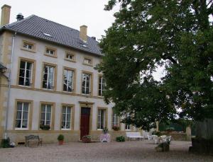 een groot wit huis met veel ramen bij Domaine de Gondrange - Chambres d'Hôtes in Havange