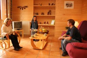 eine Gruppe von Personen, die in einem Wohnzimmer sitzen in der Unterkunft La Moraine in Villard-de-Lans