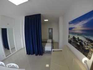 Un dormitorio con una cama y una cortina azul. en Apartamentos Juan Pérez- Viviendas Vacacionales, en Las Palmas de Gran Canaria 166 fotos más
