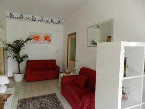 ein Wohnzimmer mit zwei roten Sofas und einem Spiegel in der Unterkunft Appartamento S. Valentino in Terni