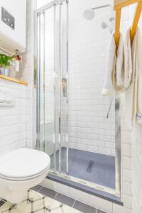 a white bathroom with a shower and a toilet at Studio Clemenceau in Aix-les-Bains