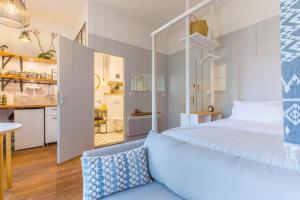 a bedroom with a large bed and a kitchen at Studio Clemenceau in Aix-les-Bains