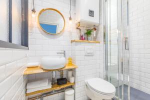 a white bathroom with a toilet and a mirror at Studio Clemenceau in Aix-les-Bains