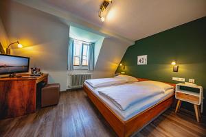 a bedroom with a large bed and a flat screen tv at Gasthaus zum Ochsen in Mannheim