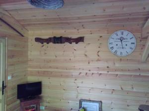 a wall with a clock and a television on it at La Grange et Le Nid in Biscarrosse