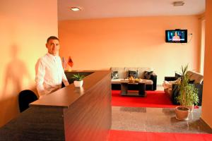 a man standing in a room with a living room at Apartments Contessa in Ulcinj