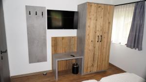 Schlafzimmer mit einem TV und einem Holzschrank in der Unterkunft Apartment Wandspitz in Hintertux