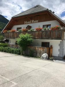 a building with a fence and flower boxes on it at Rute Hotel and Apartments in Kranjska Gora