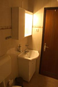 een badkamer met een wastafel, een toilet en een raam bij Nada Apartments in Poreč