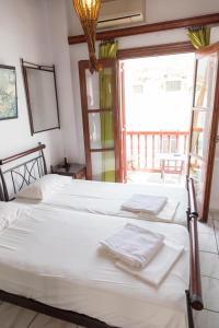 a couple of beds in a room with a window at Studio Eleni in Mikonos
