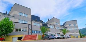 a large building with cars parked in front of it at Hotel O Camiño in O Barco de Valdeorras