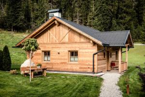 a log cabin with a table and a bench in front of it at Pradel Dolomites in San Martino in Badia