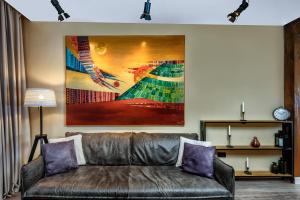 a couch in a living room with a painting on the wall at One Luxury Suites in Belgrade