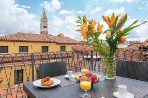 ヴェネツィアにあるVe.N.I.Ce Cera San Marco Terraceの花瓶と食べ物をバルコニーに用意したテーブル