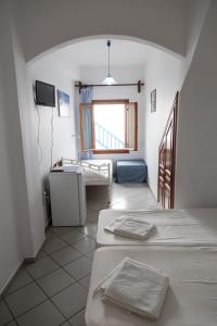 a room with two beds and a sink at Studio Eleni in Mikonos