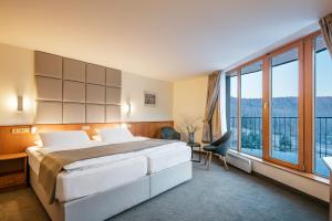 a hotel room with a bed and a large window at Hotel Ostrov in Tisá