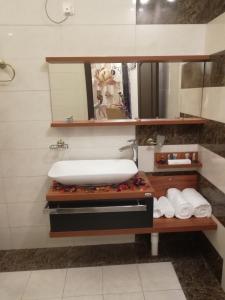 ein Badezimmer mit einem Waschbecken und Handtüchern auf einem Regal in der Unterkunft Al Worod Al Thahabia Chalets in Abha