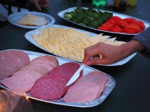 uma mesa com pratos de diferentes tipos de carnes e queijos em Festanation Oktoberfest Camp #1 em Munique