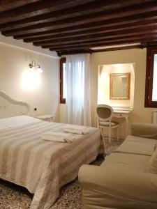 een slaapkamer met 2 bedden, een tafel en een spiegel bij Ca' Venere Apartments Cannaregio in Venetië