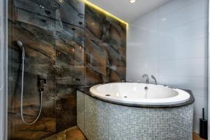 a bathroom with a tub and a shower at One Luxury Suites in Belgrade