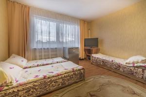 una camera d'albergo con due letti e una televisione di Pokoje goscinne Mariola a Władysławowo