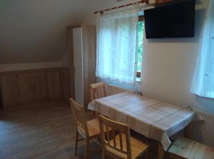ein Esszimmer mit einem Tisch, Stühlen und einem Fenster in der Unterkunft Apartment Sela in Tolmin