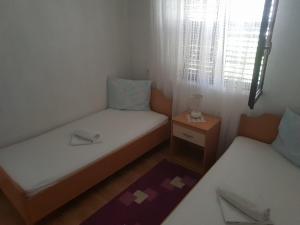 een kleine kamer met 2 bedden en een raam bij Guest House Alisa in Hvar