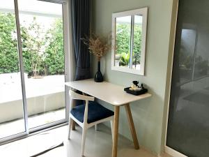 einen kleinen Tisch mit einem Stuhl und einem Spiegel in der Unterkunft Purin Resort & Restaurant- SHA Plus in Had Yao Beach