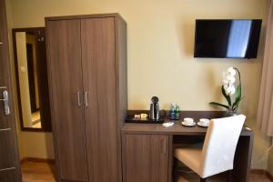 a room with a desk with a cabinet and a chair at Pokoje Gościnne Lech in Strzałkowo