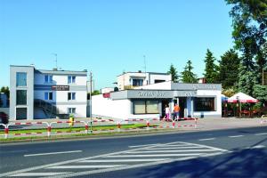 a building on the side of a street with people standing outside at Pokoje Gościnne Lech in Strzałkowo