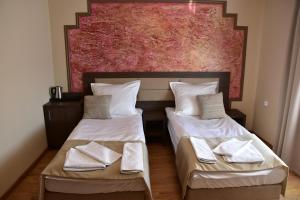 2 camas en una habitación con un cuadro en la pared en Pokoje Restauracja Lech en Strzałkowo