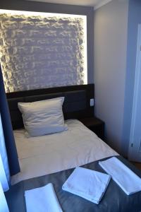1 dormitorio con 1 cama con 2 toallas en Pokoje Restauracja Lech en Strzałkowo