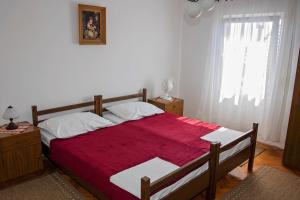 sypialnia z dużym łóżkiem i czerwonym kocem w obiekcie Apartment Ivan w Rogoznicy